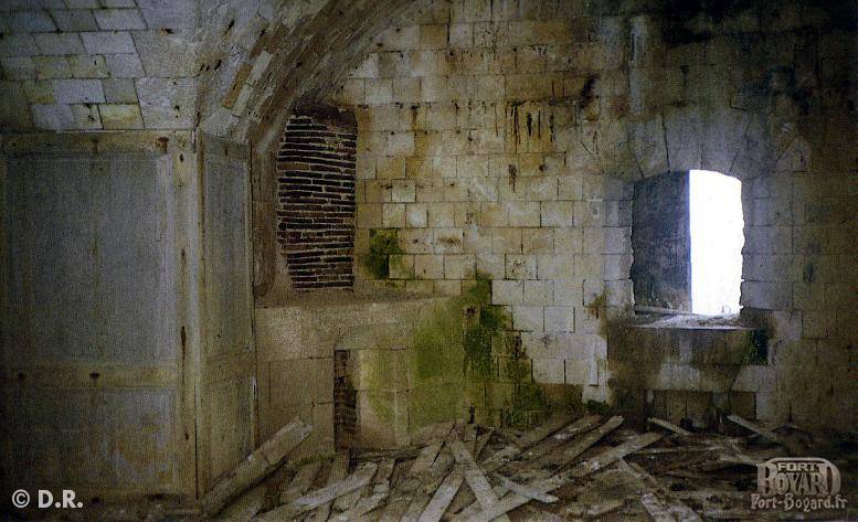 Une cellule en très mauvais état avec sa cheminée et le restant de lambris jonchant le sol(1960)